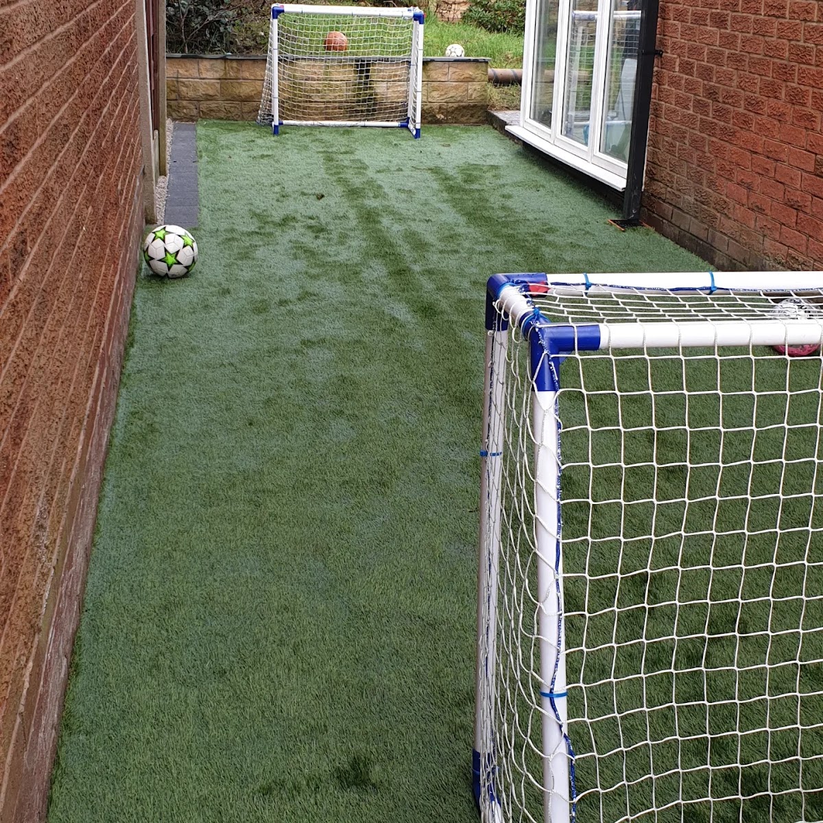 Artificial grass installation in a rear garden by MCR Resin Driveways