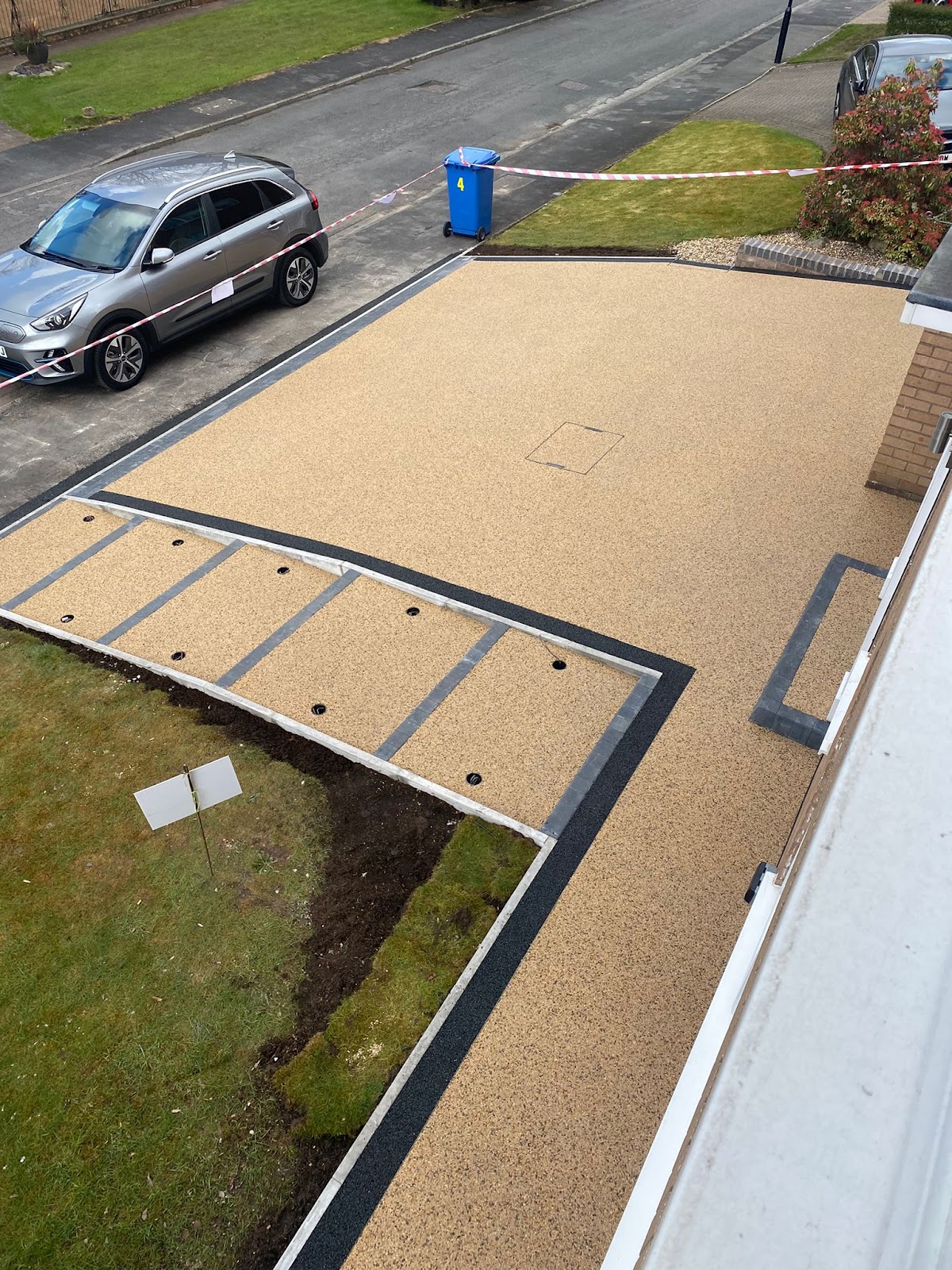 Aerial view of a golden resin driveway with drainage channel by MCR